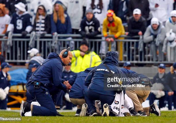 Head coach James Franklin of the Penn State Nittany Lions kneels down by injured quarterback Trace McSorley against the Iowa Hawkeyes on October 27,...