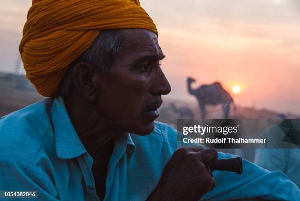 a camel trader is smoking at dusk - smoking chillum fotografías e imágenes de stock