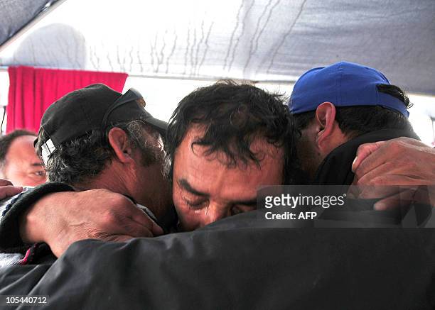 Relatives of the trapped miners celebrate after one of the drills working to rescue the 33 finally reached their shelter in the San Jose mine, near...