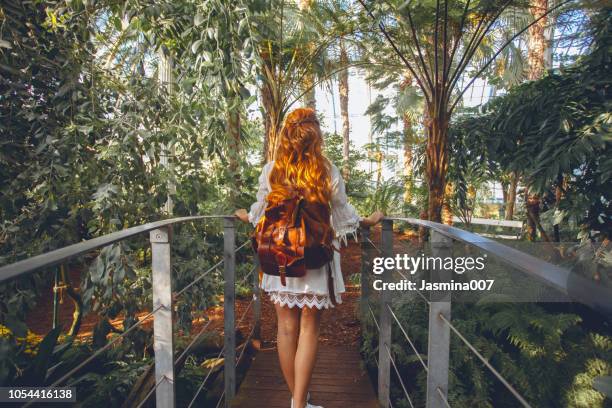 junge frau in tropischer umgebung - botanischer garten stock-fotos und bilder