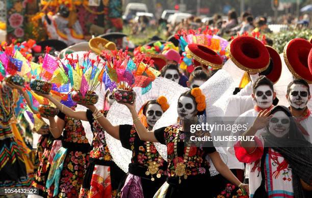 People take part in the Day of the Dead parade in Mexico City on October 27, 2018.