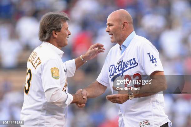 Dennis Eckersley and Kirk Gibson shake hands on the mound after throwing out a ceremonial first pitch prior to in Game Four of the 2018 World Series...