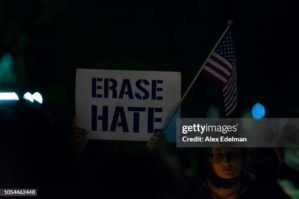 Vigil participant holds a 'Erase Hate' sign during a Havdalah vigil for the victims of the Tree of Life Congregation shooting in front of the White...