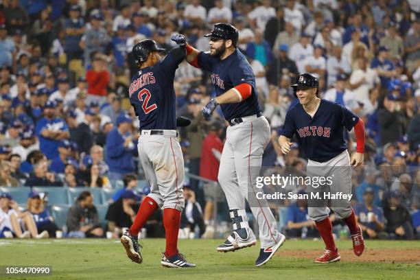 Mitch Moreland of the Boston Red Sox celebrates with Xander Bogaerts and Brock Holt after Moreland hit a three-run home run in the seventh inning...