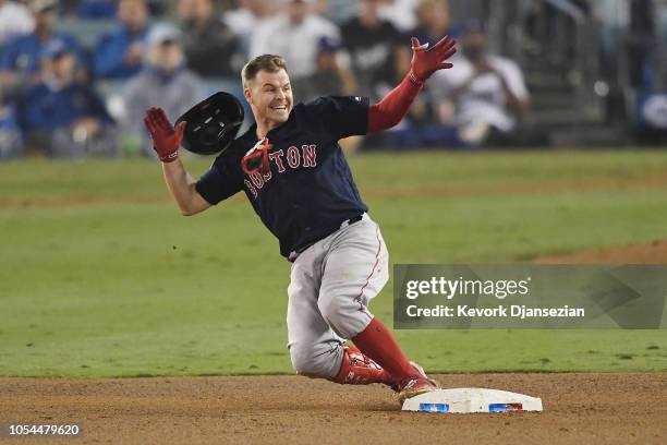 Brock Holt of the Boston Red Sox slides into second base on his one-out double to left field in the ninth inning of Game Four of the 2018 World...