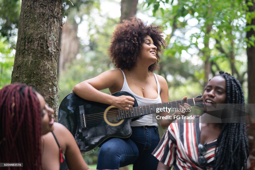 Teenager Girls Playing Guitar and Singing at Park