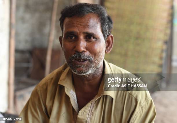 In this picture taken on October 16 Pakistani auto-rickshaw driver Mohammad Rasheed speaks during an interview with AFP in Korangi, a slum area in...