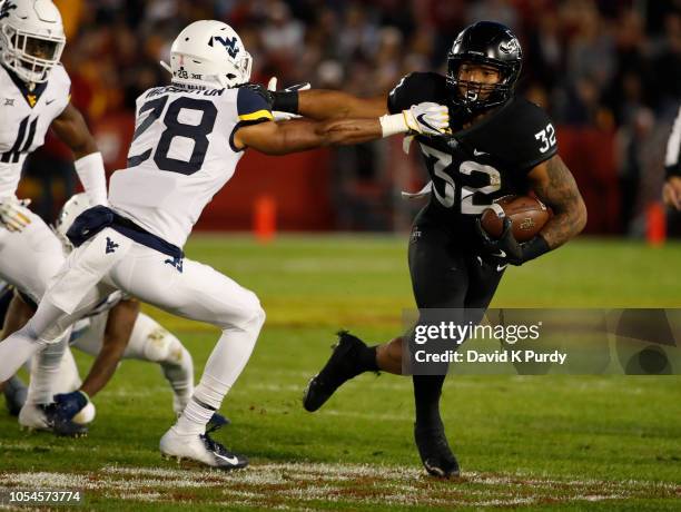 Running back David Montgomery of the Iowa State Cyclones is tackled by cornerback Keith Washington of the West Virginia Mountaineers in the first...