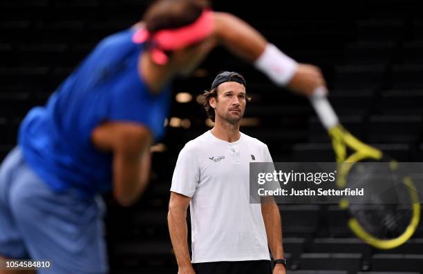 Rafael Nadal of Spain serves while coach, Carlos Moya looks on during practice ahead of the Rolex Paris Masters on October 28, 2018 in Paris, France.