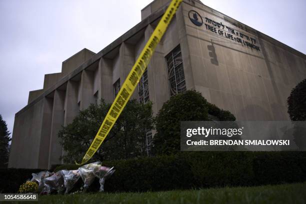 Police tape and memorial flowers are seen on October 28, 2018 outside the Tree of Life Synagogue after a shooting there left 11 people dead in the...