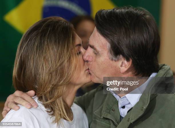Jair Bolsonaro, far-right lawmaker and presidential candidate of the Social Liberal Party , and his wife Michelle kiss before casting their votes on...