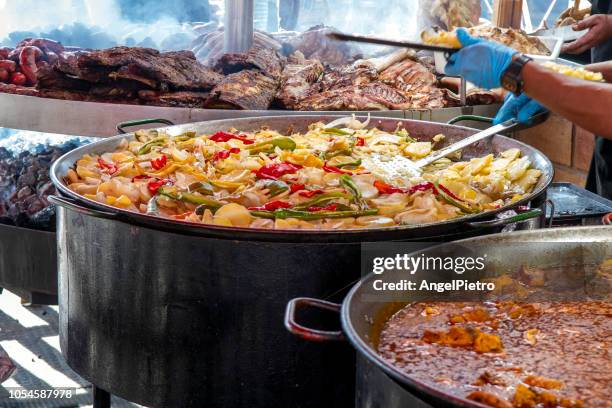 a huge skillet with cooked potatoes with pepper and other vegetables - marmite photos et images de collection