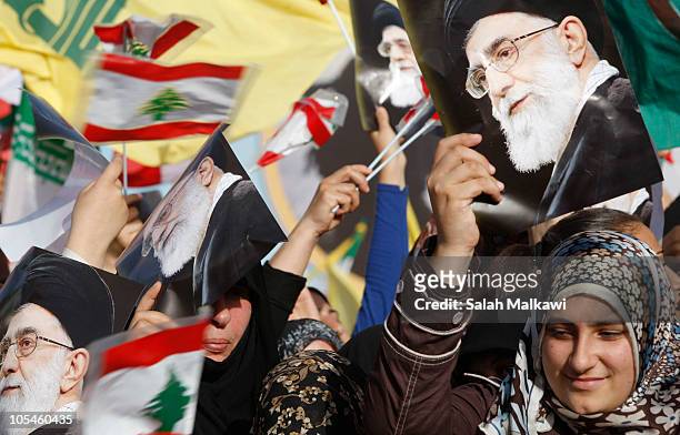 People hold up pictures of Iranian Supreme Leader Ayatollah Ali Khamene during a rally with Iranian President Mahmoud Ahmadinejad during his visit...