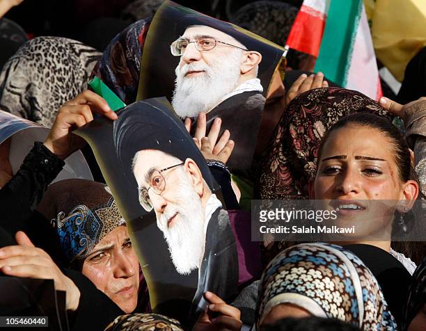People hold up pictures of Iranian Supreme Leader Ayatollah Ali Khamene during a rally with Iranian President Mahmoud Ahmadinejad during his visit...