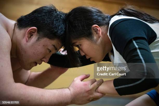 Kotone Hori, a member of Asahi University's women's sumo team, wrestles with a male opponent during a training session at the university sumo gym on...