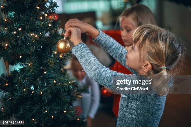 decorare l'albero di natale con ornamenti e luci di natale - decorare l'albero di natale foto e immagini stock