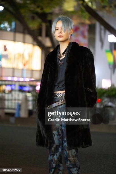 Local is seen on the street in Harajuku wearing black fur coat, grey shirt, blue face pattern pants and platform shoes on October 28, 2018 in Tokyo,...
