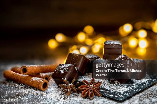 chocolate dominoes with powdered sugar, cinnamon sticks - christmas cake fotografías e imágenes de stock