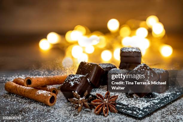 chocolate dominoes with powdered sugar, cinnamon sticks - confiserie mets sucré photos et images de collection
