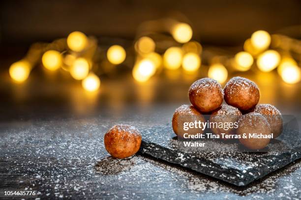 marzipan balls with powdered sugar on wooden board with slate plate and candlelight. - kartoffelblüte nahaufnahme stock-fotos und bilder