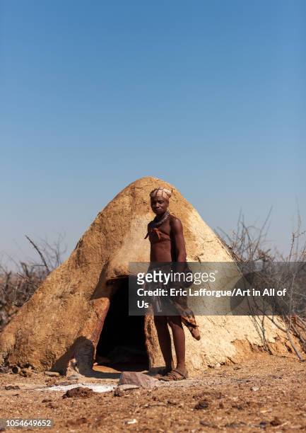 Himba tribe man standing in front of his mud hut, Cunene Province, Oncocua, Angola on August 14, 2010 in Oncocua, Angola.