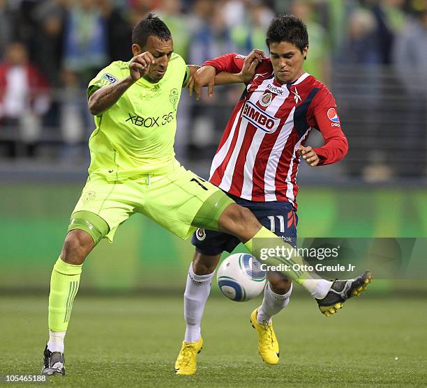 Tyrone Marshall of the Seattle Sounders FC dribbles against Ulises Davila of Chivas de Guadalajara on October 12, 2010 at Qwest Field in Seattle,...