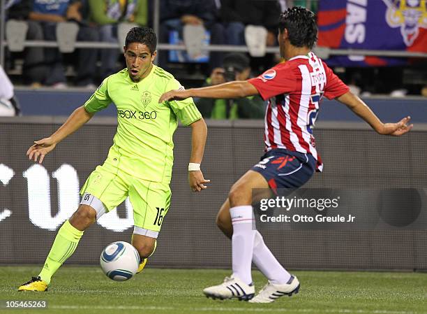 David Estrada of the Seattle Sounders FC dribbles against Juan Ocampo of Chivas de Guadalajara on October 12, 2010 at Qwest Field in Seattle,...