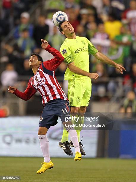 Ulises Davila of Chivas de Guadalajara heads the ball against Michael Seamon of the Seattle Sounders FC on October 12, 2010 at Qwest Field in...