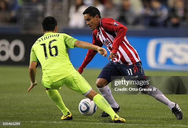 Mitchel Oviedo of Chivas de Guadalajara dribbles against David Estrada of the Seattle Sounders FC on October 12, 2010 at Qwest Field in Seattle,...