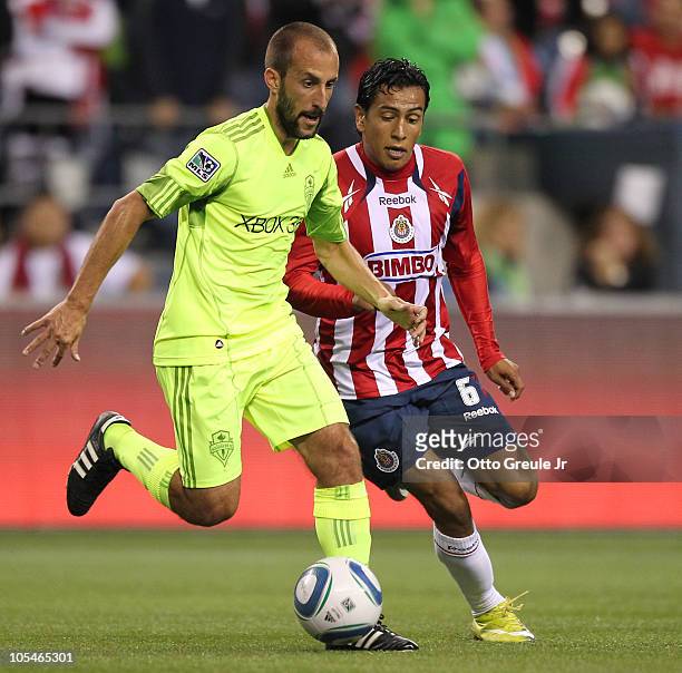 Omar Esparza of Chivas de Guadalajara dribbles against Peter Vagenas of the Seattle Sounders FC on October 12, 2010 at Qwest Field in Seattle,...