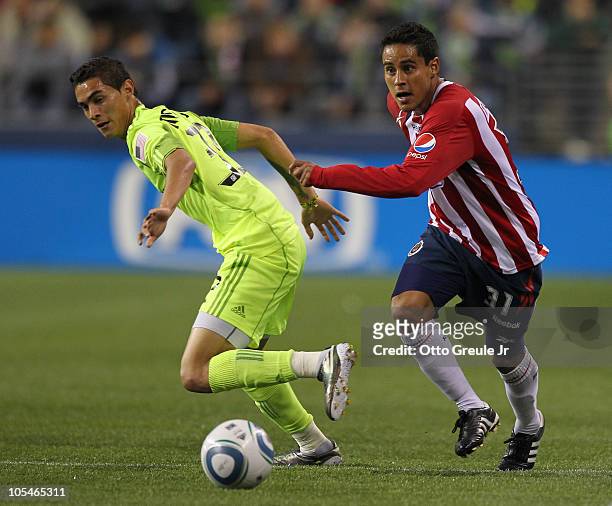 Mitchel Oviedo of Chivas de Guadalajara dribbles against Miguel Montano of the Seattle Sounders FC on October 12, 2010 at Qwest Field in Seattle,...