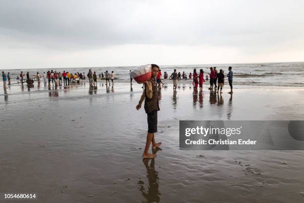 Cox´s Bazar, Bangladesh A boy from Bangladesh, a street vendor who has to do child labor is posing into the camera at the beach. The beach of Cox's...