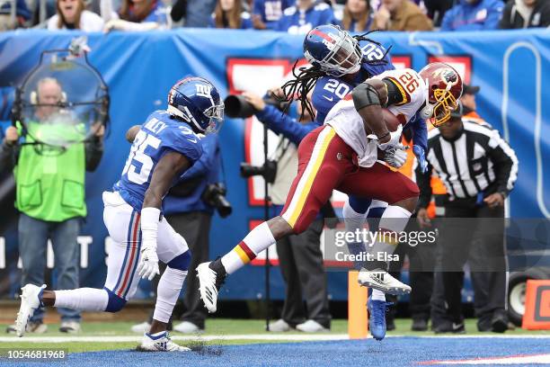 Adrian Peterson of the Washington Redskins scores a touchdown defended by Janoris Jenkins of the New York Giants during the first quarter at MetLife...