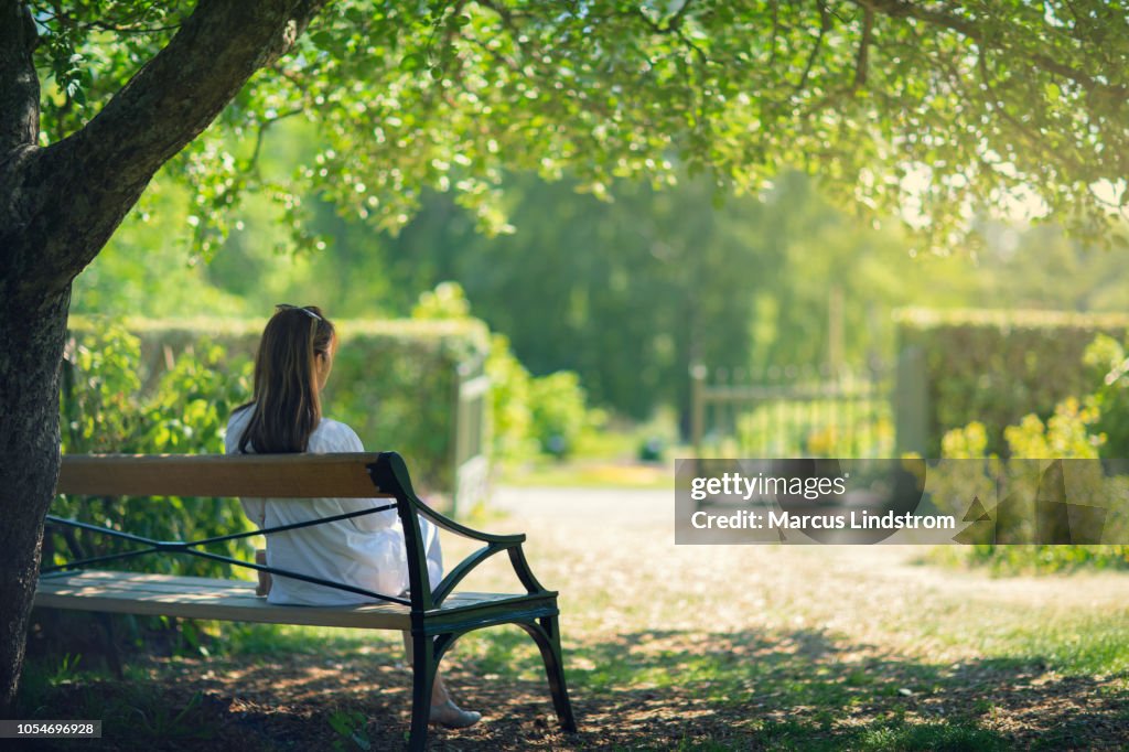 一個在綠色花園裡放鬆的女人