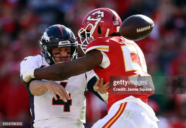 Quarterback Case Keenum of the Denver Broncos loses the ball as he is tackled by linebacker Reggie Ragland of the Kansas City Chiefs during the game...