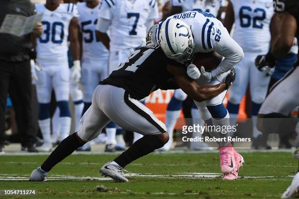 Eric Ebron of the Indianapolis Colts is tackled by Marcus Gilchrist of the Oakland Raiders during their NFL game at Oakland-Alameda County Coliseum...