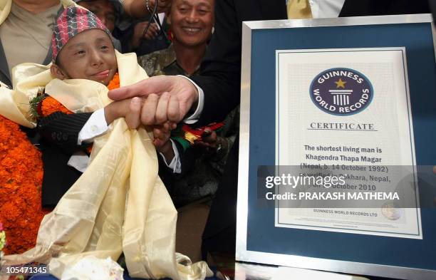 Guinness World Records official Marco Frigattihand shands hands with Khagendra Thapa Magar after being named as the world's shortest man at a...