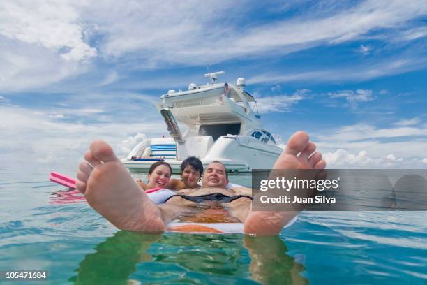 man with family at beach - luxury yachts stockfoto's en -beelden