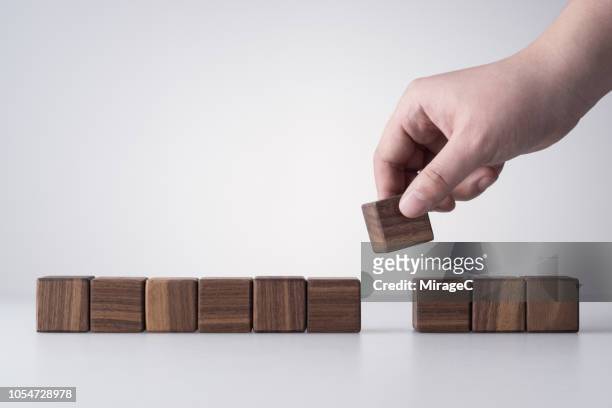 hand removing a wood blocks - hand picking up stock pictures, royalty-free photos & images