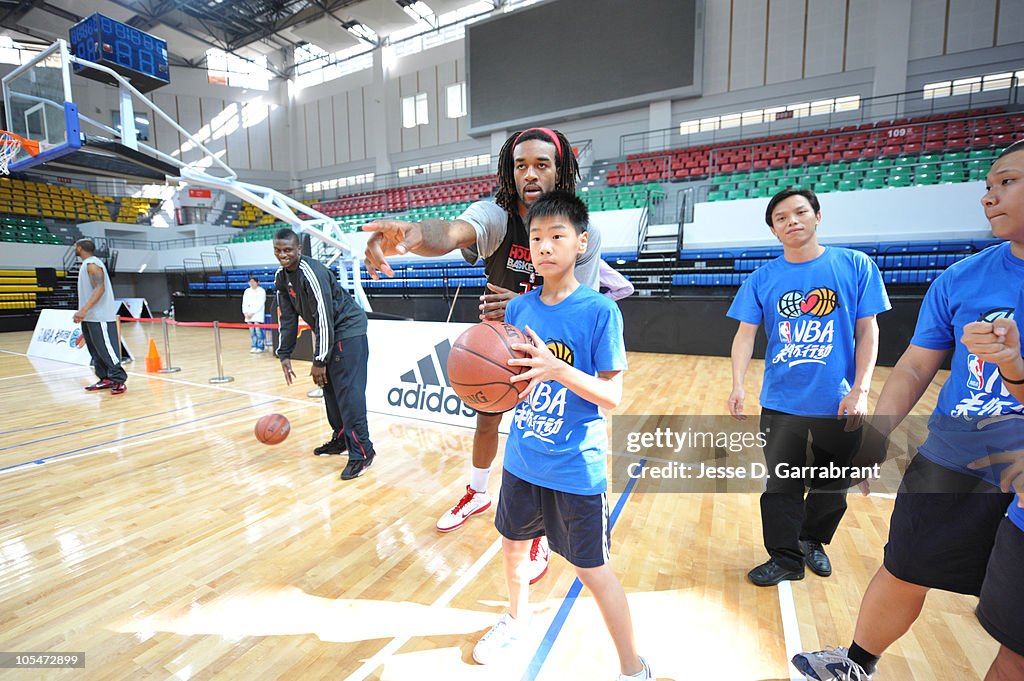 Jordan Hill of the Houston Rockets works with a student during an NBA ...