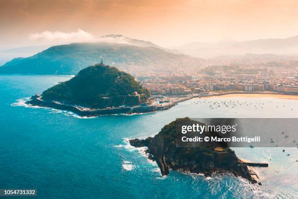 san sebastian and santa clara island at sunset - baskenland spanje stockfoto's en -beelden