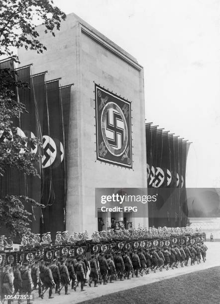 Members of the Nazi Sturmabteilung marching past the Luitpoldhalle with their banners at the Nuremberg Rally to mark the 8th Nazi Party Congress, 9th...