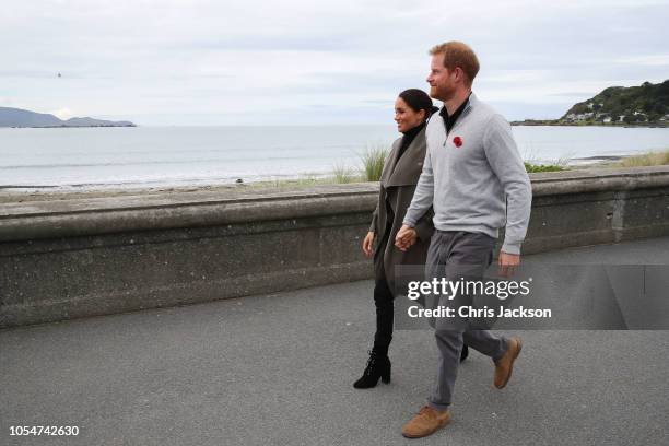 Prince Harry, Duke of Sussex and Meghan, Duchess of Sussex walking along Lyall Bay to visit Maranui Cafe on October 29, 2018 in Wellington, New...