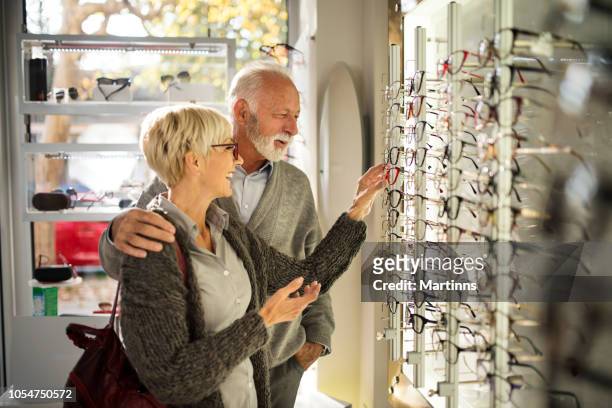 senior couple shopping for eyeglasses - choosing eyeglasses stock pictures, royalty-free photos & images