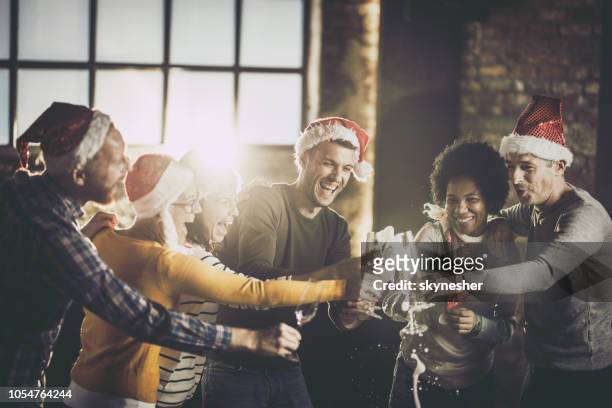 freudige geschäftsteam spaß beim öffnen champagner während der weihnachtsfeier im büro. - christmas party office stock-fotos und bilder