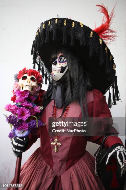 People dressed as Catrin and Catrina pose for photo in festival celebrating the day of Los Muertos in Sao Paulo on October 28, 2018.