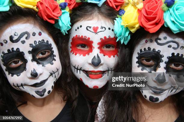 People dressed as Catrin and Catrina pose for photo in festival celebrating the day of Los Muertos in Sao Paulo on October 28, 2018.