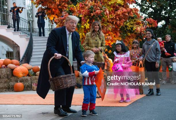 President Donald Trump and First Lady Melania Trump give out candy to children at a Halloween celebration at the White House in Washington, DC, on...