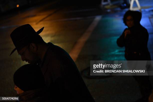 People's silhouettes are seen as they walk near a memorial on October 28, 2018 outside the Tree of Life synagogue after a shooting there left 11...