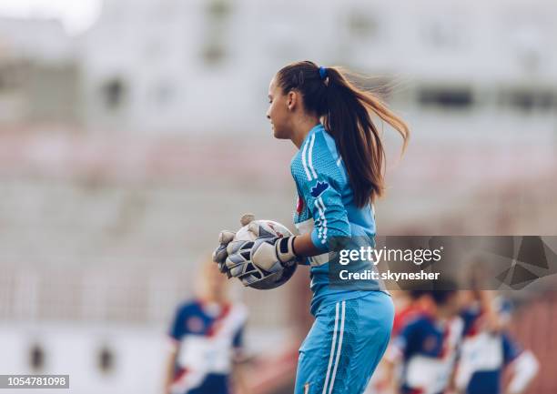 vrouwelijke voetbaldoelman met een bal op een stadion. - goalkeeper soccer stockfoto's en -beelden